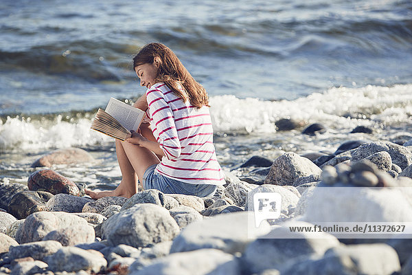 Frau liest Buch am Strand