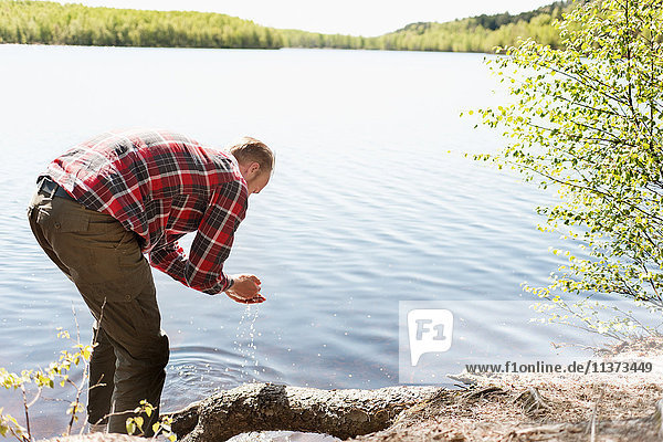 Man washing hands in lake