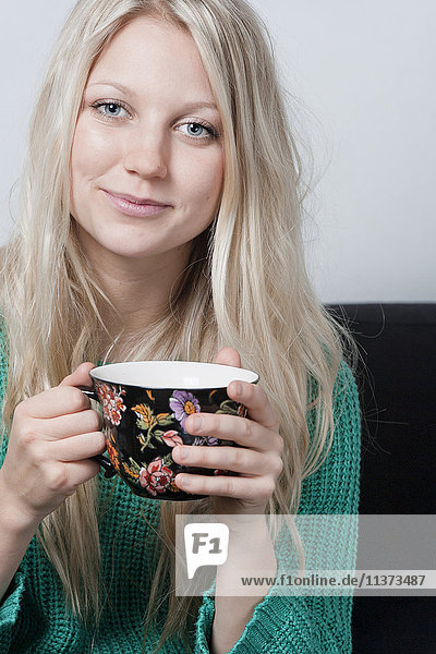 Portrait of young woman with coffee cup