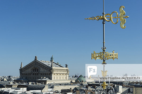 France. Paris 9th district. Weather vane of the terrace of the department store Au Printemps. Background: the Garnier Opera