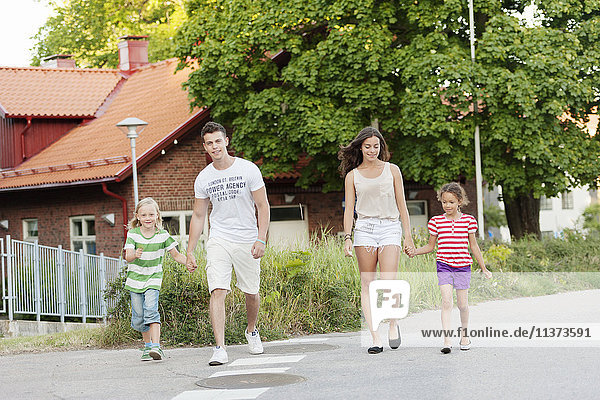 Young couple walking in street with siblings