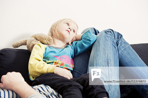 Girl relaxing with mother on sofa