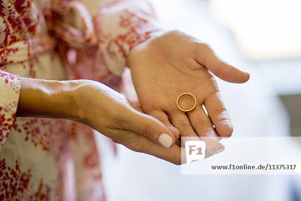 Caucasian woman holding wedding ring