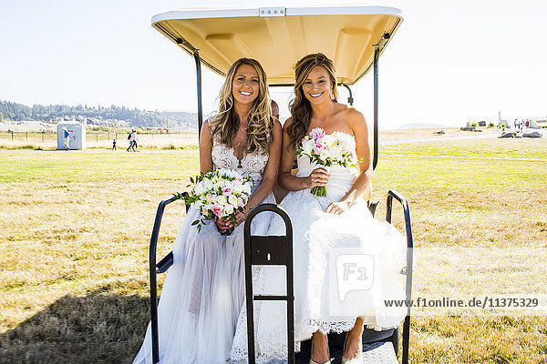 Caucasian brides sitting in golf cart
