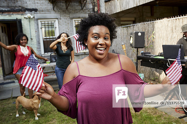 Women celebrating with American flags in backyard