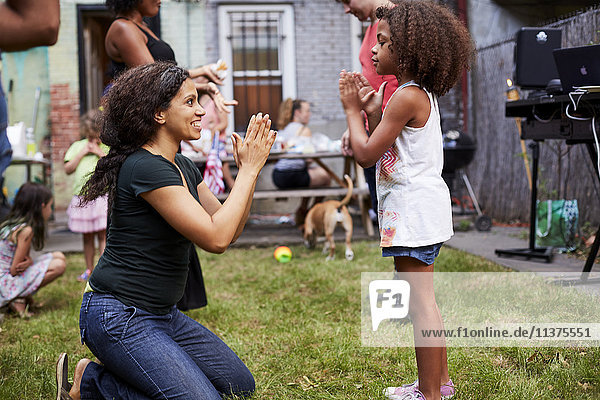 Mixed Race Mutter und Tochter spielen Klatschspiel