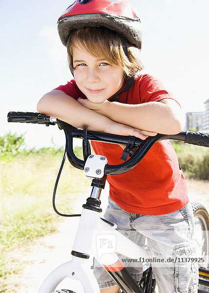 Kaukasischer Junge lehnt sich an einen Fahrradlenker