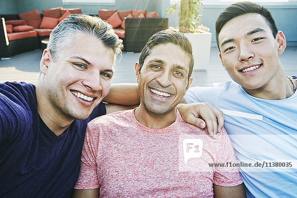 Smiling men posing on rooftop