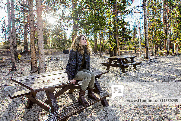 Caucasian woman sitting on picnic table
