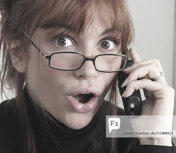 Überrascht Kaukasische Geschäftsfrau am Telefon
