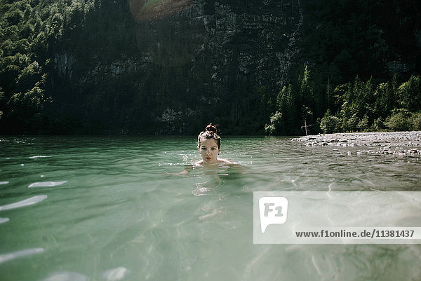 Kaukasische Frau beim Schwimmen im Bergsee