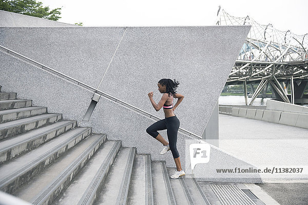 Gemischtrassige Frau läuft eine städtische Treppe hinauf