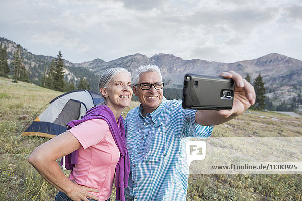 Kaukasisches Paar posiert für Handy-Selfie auf Berg