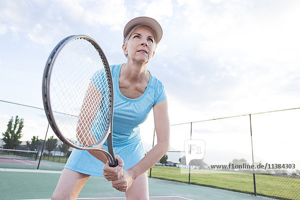 Kaukasische Frau hält Tennisschläger
