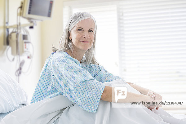 Porträt einer lächelnden kaukasischen Frau im Krankenhausbett