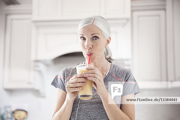 Caucasian women drinking smoothie with straw
