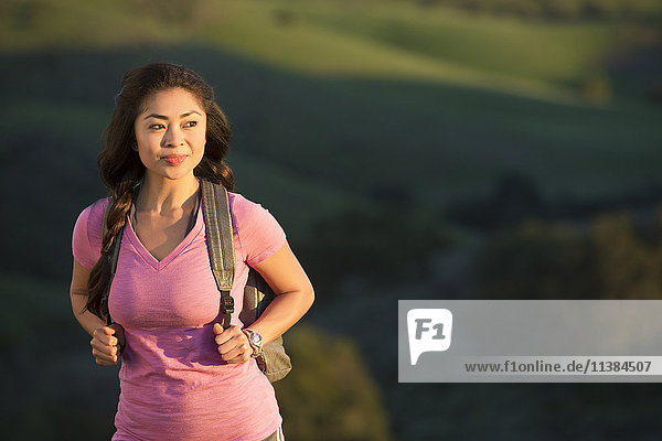Asian woman hiking on hill