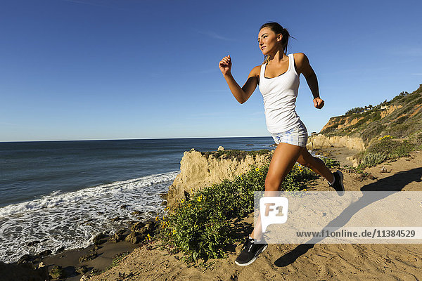 Caucasian woman running on beach
