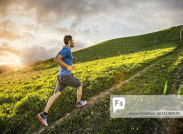 Hispanic man running on hill