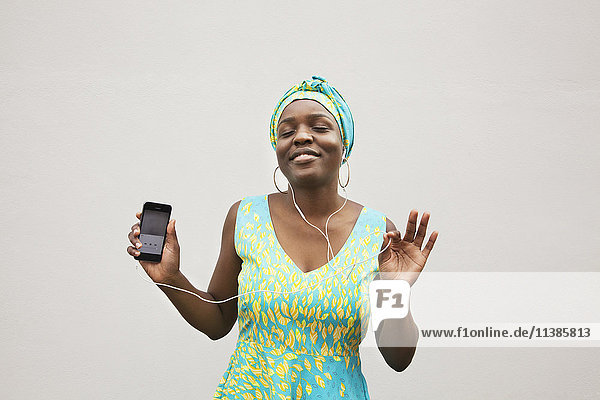 Schwarze Frau tanzt zu Musik auf einem Mobiltelefon
