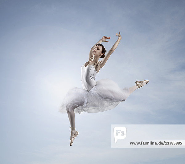 Kaukasische Ballerina tanzt im Himmel