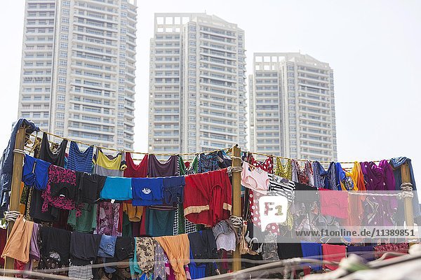 Bunte Kleidung auf einer Wäscheleine vor Wolkenkratzern  Wäschereiviertel Dhobi Ghat  Mahalaxmi  Mumbai  Maharashtra  Indien  Asien