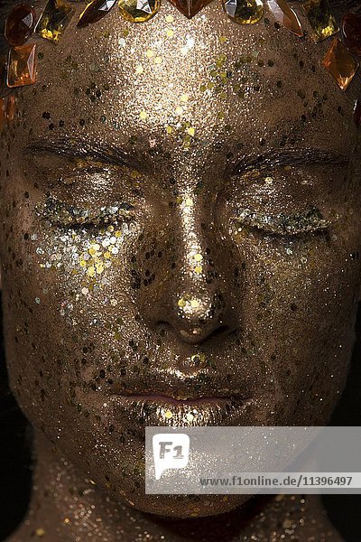 Portrait  young woman with golden glitter makeup