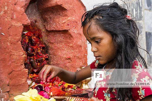 Kleines Mädchen  das den Götterstatuen vor dem Khadga-Devi-Tempel Prasad anbietet  Hindu-Fest Darsain  Bandipur  Tanahun-Distrikt  Nepal  Asien