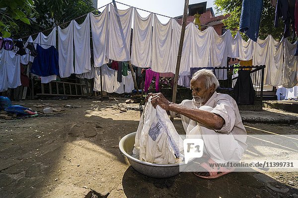 Mann wäscht Wäsche mit der Hand im Innenhof  Kathmandu  Kathmandu District  Nepal  Asien