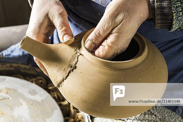Keramikwerkstatt  Hände prüfen den Sitz der Tülle auf dem Topf  Pittenhart  Oberbayern  Deutschland  Europa