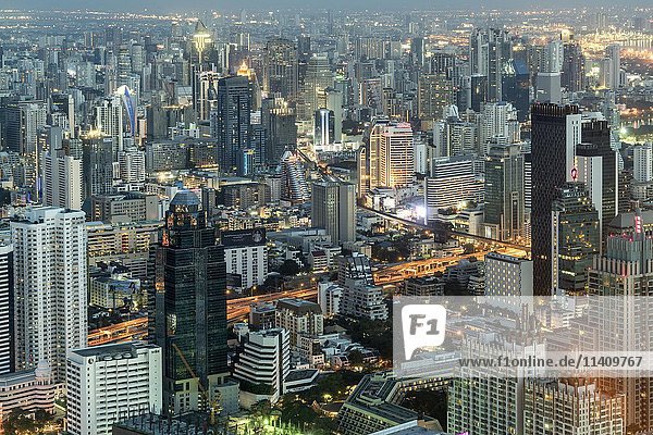 Skyline mit Wolkenkratzern  beleuchtete Straße  Stadtbild in der Abenddämmerung  Bangkok  Thailand  Asien