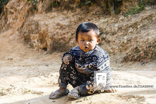 Little boy sitting on the ground  Palaung hilltribe  Palaung Village in Kyaukme  Shan State  Myanmar  Asia