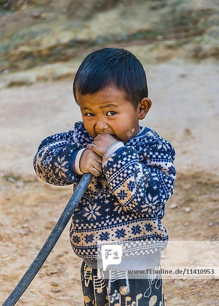 Little boy blowing into hose  Palaung hilltribe  Palaung Village in Kyaukme  Shan State  Myanmar  Asia
