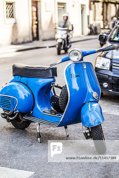 Ein klassischer blauer Vespa-Roller  geparkt auf einer Kopfsteinpflasterstraße; Rom  Latium  Italien'.