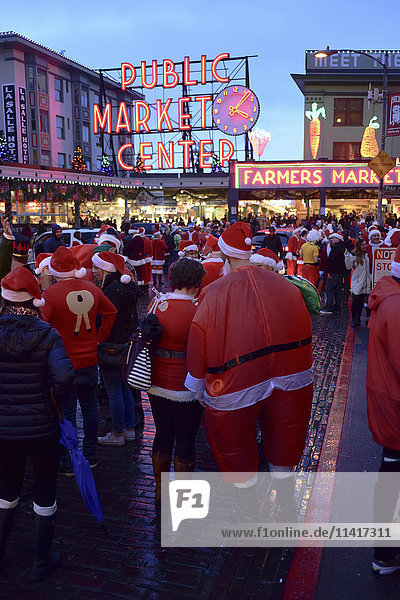 Die Drunk santas Christmas Party   eine traditionelle jährliche Zusammenkunft von Hunderten von fröhlichen Weihnachtsfeiernden  die durch die Innenstadt von Seattle ziehen und dabei auch einen Halt am weltberühmten Pike Place Public Market machen; Seattle  Washington  Vereinigte Staaten'.