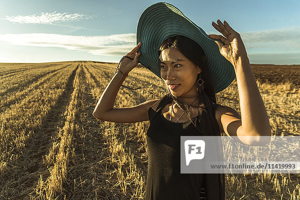 'Chinese young woman walking in a wheat field; Madrid Spain'