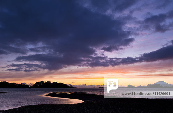 Dramatischer Himmel bei Sonnenuntergang über dem Ozean und der silhouettierten Küstenlinie; Sitka  Alaska  Vereinigte Staaten von Amerika