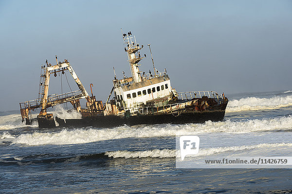 Ein rostiges  gesunkenes  verlassenes Schiff in den Wellen des Atlantiks an der namibischen Küste (Zeila Shipwreck); Namibia'.