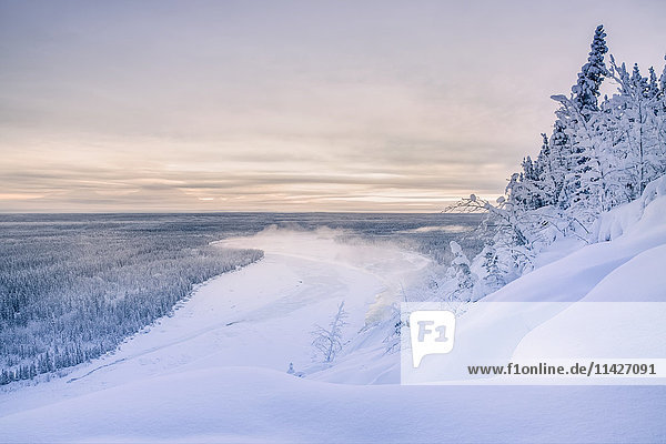 Nebel steigt am Copper River an einem kalten Winterabend auf  das warme Licht des Sonnenuntergangs wirft den Mount Drum im Hintergrund in den Schatten  Copper River Valley  Süd-Zentral-Alaska; Alaska  Vereinigte Staaten von Amerika'.