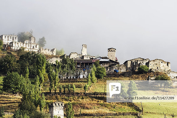 'Village with Svan towers between Mestia and Ushguli in low clouds  Upper Svaneti; Samegrelo-Zemo Svaneti  Georgia'