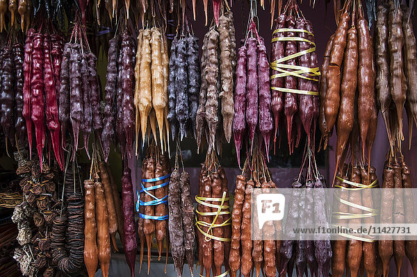 'Churchkhela  traditional Georgian candies made from nuts  almonds  walnuts and hazelnuts threaded onto a string  dipped in thickened grape juice or fruit juices and dried; Tbilisi  Georgia'