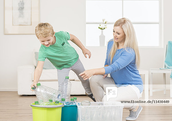 Recycling - Mutter und Sohn sortieren Flaschen