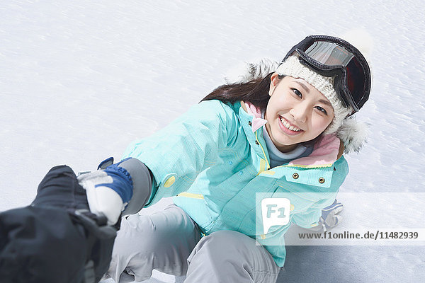 Junge Japanerin beim Snowboarden