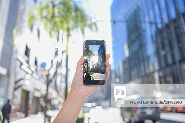 Japanese woman using augumented reality app on smartphone downtown Tokyo  Japan