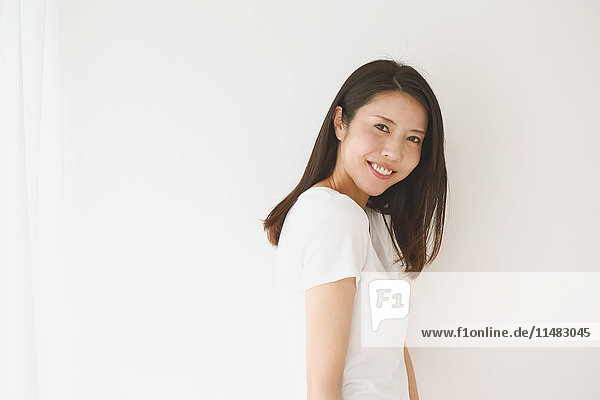 Portrait of young Japanese woman in a white room