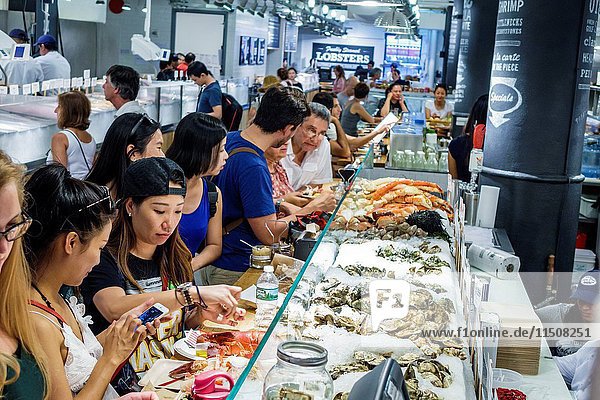 New York  New York City  NYC  Manhattan  Chelsea  Chelsea Market  The Lobster Place Seafood Market  raw bar  dining  counter  Asian  woman  friends  eating  display  oysters