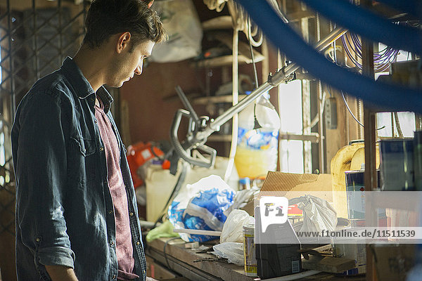 Man searching through cluttered attic for misplaced item