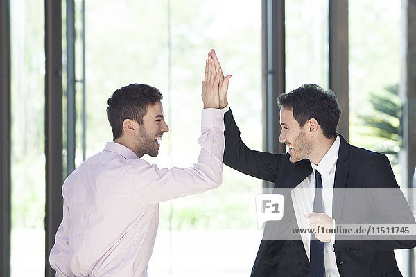 Businessmen congratulating each other with high-five