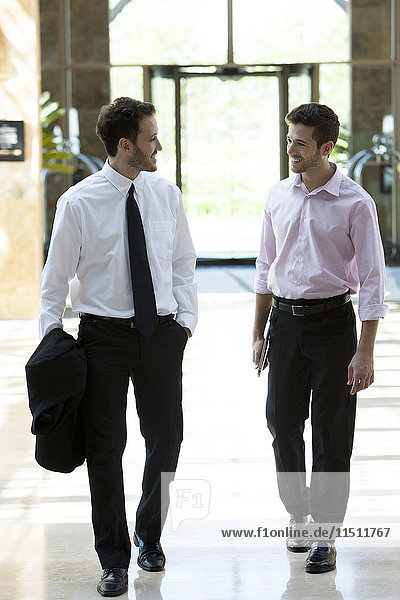 Business colleagues chatting while walking together