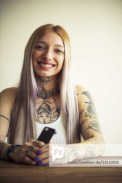 Tattooed woman using smartphone  portrait